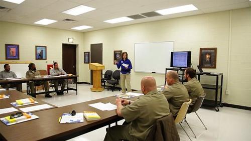 Incarcerated men listen attentively to their instructor